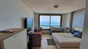 - une chambre avec un lit et une vue sur l'océan dans l'établissement Prestigia bouknadel, à Sidi Bouqnadel