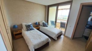 Cette chambre dispose de deux lits et d'un balcon. dans l'établissement Prestigia bouknadel, à Sidi Bouqnadel