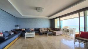 - un salon avec un canapé bleu et une grande fenêtre dans l'établissement Prestigia bouknadel, à Sidi Bouqnadel