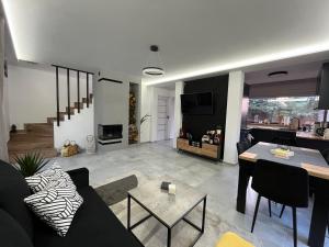 a living room with a couch and a table at Modern Village in Nowinka