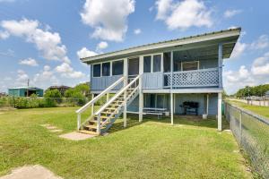 a blue house with a porch and a staircase at Pet-Friendly Texas Escape with Deck and Fenced-In Yard in Freeport