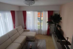 a living room with a white couch and red curtains at Charme Provenzale in Menton