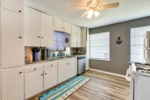 a kitchen with white cabinets and a ceiling fan at Pet-Friendly Texas Escape with Deck and Fenced-In Yard in Freeport