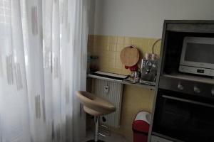 a small kitchen with a microwave and a stool at Charme Provenzale in Menton