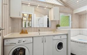 a bathroom with a washing machine and a sink at Gorgeous Home In Hals With Sauna in Hals