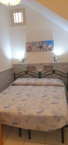 ein Schlafzimmer mit einem Bett in einem Zimmer in der Unterkunft La Casa di Lola in Alcamo