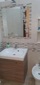 ein Bad mit einem Waschbecken und einem Spiegel in der Unterkunft La Casa di Lola in Alcamo