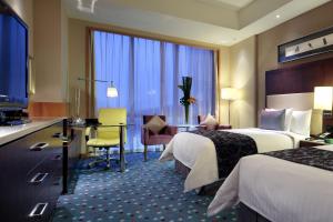 a hotel room with two beds and a desk at Courtyard by Marriott Suzhou in Suzhou