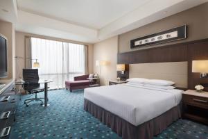 een hotelkamer met een groot bed en een bureau bij Courtyard by Marriott Suzhou in Suzhou