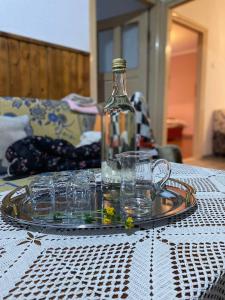 a glass plate with glasses and a bottle on a table at Seosko Domaćinstvo Vulević in Andrijevica