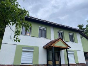 una casa con pintura verde y blanca. en Seosko Domaćinstvo Vulević, en Andrijevica