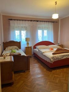 2 camas en un dormitorio con suelo y ventanas de madera en Seosko Domaćinstvo Vulević, en Andrijevica