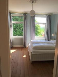 Schönberg in HolsteinにあるVilla Baltica - Wintergarten-Appartementのベッドルーム1室(ベッド1台、窓2つ付)