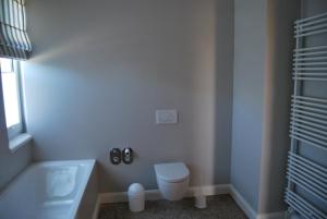 a bathroom with a toilet and a bath tub at Villa Baltica - Wintergarten-Appartement in Schönberg in Holstein