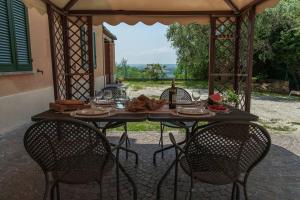 Villa Fiore nel Borgo d'Arte Novilara by Yohome في Novilara: طاولة مع كراسي وكؤوس للنبيذ على الفناء