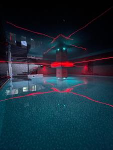 Hotel Sara & SPA في بريشتيني: حمام سباحة في الليل مع أضواء حمراء