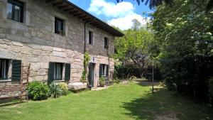 una casa de piedra con un patio al lado de un edificio en Conjunto Entre Acebos, en Sotillo de Sanabria