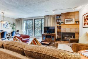 a living room with a couch and a tv at Impeccable Ski In Ski Out Unit with Mountain Views from Private Balcony, Steps From Downtown TE402 in Breckenridge