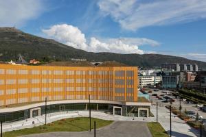 a large orange building in front of a city at Moxy Bergen in Bergen