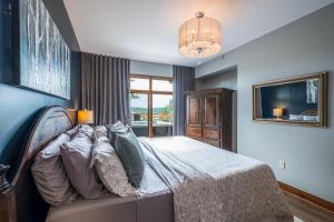 1 dormitorio con cama y lámpara de araña en Tremblant Prestige-Altitude 170-1 en Mont-Tremblant