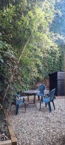 einen Picknicktisch und zwei Stühle in einem Garten in der Unterkunft Stylish 2 Bed, Business & Leisure. Wifi and private garden; by First Serve - West Wimbledon in Raynes Park