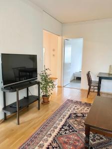 ein Wohnzimmer mit einem Flachbild-TV und einem Tisch in der Unterkunft Woodpecker Avenue Apartment Turku in Turku