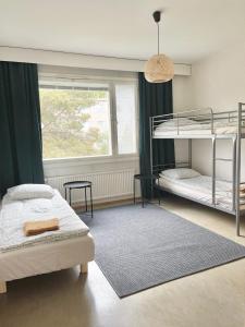 1 Schlafzimmer mit 2 Etagenbetten und einem Fenster in der Unterkunft Woodpecker Avenue Apartment Turku in Turku