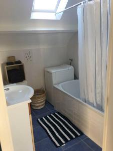 a bathroom with a sink and a tub and a toilet at Appartement 4 personnes Centre Dinard in Dinard
