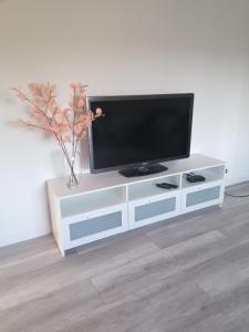 ein weißes Entertainment-Center mit einem Flachbild-TV darauf in der Unterkunft Apartament Kasztanowa 2 in Mosty