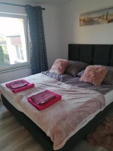ein Bett mit zwei Handtüchern und einem Fenster in der Unterkunft Apartament Kasztanowa 2 in Mosty