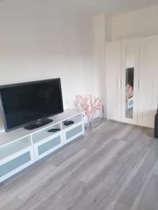 ein Wohnzimmer mit einem Flachbild-TV auf einem weißen Schrank in der Unterkunft Apartament Kasztanowa 2 in Mosty
