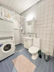 ein Badezimmer mit einem WC und einer Waschmaschine in der Unterkunft Woodpecker Avenue Apartment Turku in Turku