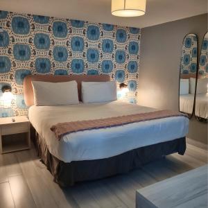 a bedroom with a large bed with blue and white wallpaper at Trópica Beach Hotel in San Juan