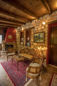 a living room with a couch and a stone wall at Ersis in Neochori