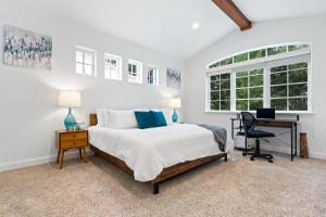 Habitación blanca con cama y escritorio en Gorgeous Santa Cruz Villa - Modern Beachside Paradise with NEW Hot Tub & Fast Wi-Fi, en Santa Cruz