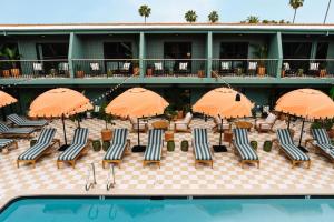 un complejo con sillas y sombrillas y una piscina en Palihotel Hollywood, en Los Ángeles