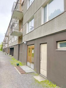 ein Gebäude mit Türen und Bürgersteig neben einer Straße in der Unterkunft Woodpecker Avenue Apartment Turku in Turku