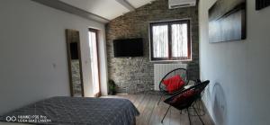 a bedroom with a bed and a brick wall at Apartment Sunrise Garden and Sea view in Vodnjan