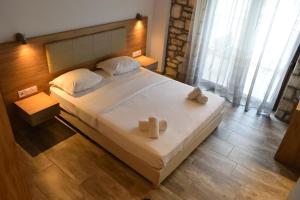 克里斯阿穆迪亚Dioscuri Deluxe Apartments的一间卧室，有一张大床，床上有两条毛巾
