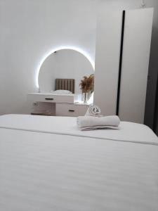 a white bedroom with a bed and a mirror at VILA PUSHIMI REGIS in Velipojë