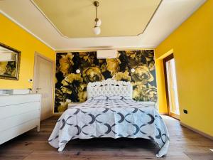 a bedroom with a bed and a yellow wall at B&B L’Orizzonte Infinito in Chiaromonte