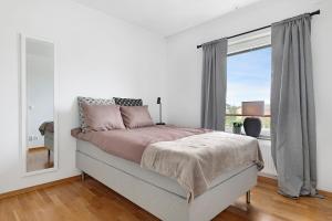 Habitación blanca con cama y ventana en Guestly Homes - 3BR Modern Apartment en Piteå