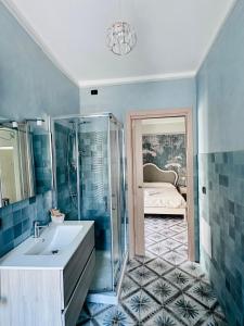 a bathroom with a sink and a shower and a bedroom at B&B L’Orizzonte Infinito in Chiaromonte