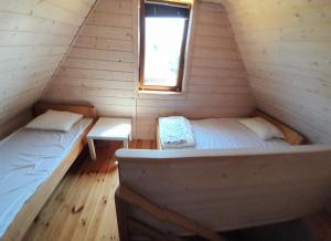 ルシノボにあるBursztynowe domkiのベッド2台付きの客室で、キャビン内に窓があります。