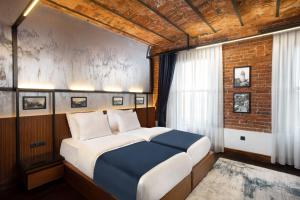 a large bed in a room with a brick wall at DeCamondo Galata, a Tribute Portfolio Hotel in Istanbul