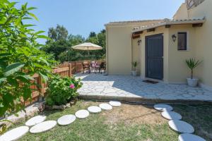 a backyard with a patio with white plates on the grass at Saralen cottage in North Corfu 