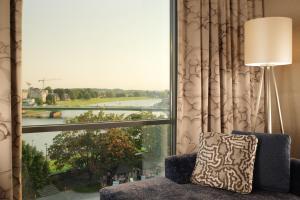 a room with a large window looking out at a river at Sheraton Grand Krakow in Krakow