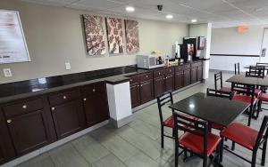 a restaurant with a counter and tables and chairs at Red Roof Inn & Suites Duncan in Duncan