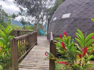 una pasarela de madera que conduce a una casa con techo en Tambo Eco Hotel en La Vega