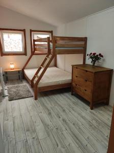 a bedroom with two bunk beds and a wooden dresser at Boszkowo Domki-Stonki in Boszkowo